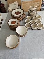 Full spread of all plates, bowls, cups and saucers on table