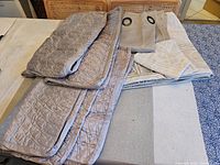 Photo of folded duvet cover, pillow shams, and curtains laid on table