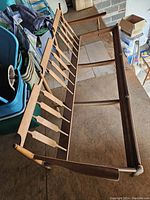 Photo of the mid century solid maple 3 seater sofa frame showing the side and back with wood slats and tapered legs.