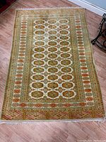 Full view of the 4ft x 6ft hand woven wool rug on wooden flooring showing overall pattern and shape.