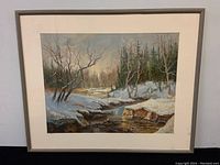 Framed pastel painting showing winter scene with snow, trees and stream in landscape orientation