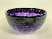 Side view of the purple blown glass bowl with black dots pattern showing shape and coloration.