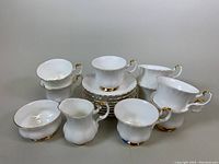 Full view of cream, sugar bowl, teacups stacked on saucers showing overall set composition