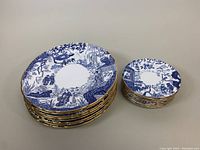 Stacks of eight large dinner plates and nine smaller dessert plates side by side