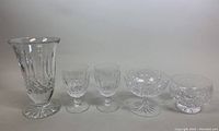Photo showing full set of crystal items including vase, two goblets, compote bowl, and footed bowl.