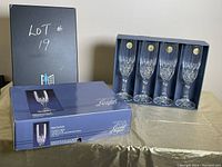 Four boxed Cristal D'Arques crystal champagne flutes in original packaging with box shown.