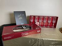 Boxed set of six Opera crystal champagne flutes by Royal Crystal Rock with red branded box open showing glasses inside.