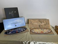 Two boxed sets of Canadian quarter coin collections from 1999 and 2000, arranged on a table, with the case covers and coin trays visible.