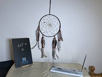Dream catcher hanging from a stand with soapstone desk set base visible underneath