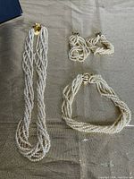 Overhead clear photo showing the full jewelry set laid flat on a surface including the necklace, bracelet, and earrings.