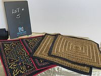 Four pillow cases showing two black with gold and red designs and two gold with an inverted square pattern, laid flat to display design and condition.