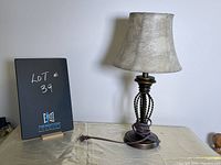 Full view of the brass table lamp with bell-shaped shade, showing its base, twisted rope design, and textured shade.