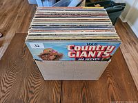Top view of vinyl records in a cardboard box showing 'Country Giants Vol 6 Jim Reeves' on top