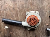 Side view of Stihl BG 55 leaf blower showing orange and off-white engine housing and black tube.