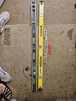 Photo of all 5 levels arranged on a carpet surface showing 2 long and 3 small magnetic edge levels with shoes for scale.