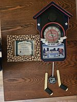 Montreal Canadiens cuckoo clock placed on a wooden table next to a framed certificate of authenticity.
