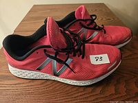 Side view showing pink mesh and black inner lining, New Balance logo on side, and white cushioned sole