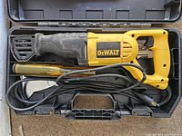 DeWalt corded reciprocating saw with power cord inside a black plastic carrying case.