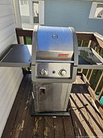 Front view of the Coleman propane BBQ grill with closed lid and control knobs visible.