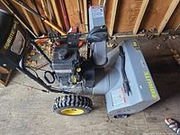 Angled left-side overview showing engine, auger housing, wheels and overall condition