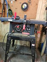 Full view of Craftsman 10-inch table saw on metal stand, showing controls and power cord.