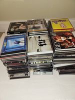Photo showing several stacks of assorted music audio CDs on a flat surface
