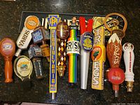 Overview of 11 tap handles on bar mat showing various brands including Yards, Samuel Adams, Ommegang, Irish Brewing Company, Victory, Troegs, and Sly Fox.