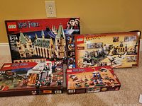 All four boxed LEGO sets arranged on carpet against wall