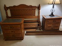 Full view of bed frame parts including headboard, footboard, rails, and two matching nightstands showing black slate inserts on top.