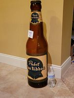 Full view of bottle next to standard water bottle for scale