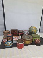 Wide shot of all tins and globe arranged against a plain backdrop