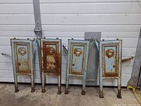 Four vintage cast iron church pew ends, two right side and two left side, arranged side by side with pale blue paint and rust.