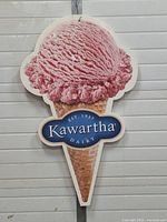 Full image of the ice cream cone sign showing a pink scoop and cone with Kawartha Dairy logo.