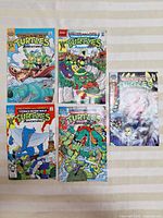 Lot of five Teenage Mutant Ninja Turtles Adventures comic books laid out on a surface, cover details visible.