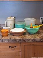 Photo of all vintage Tupperware items including pitcher, bowls, containers, and serving utensils on countertop