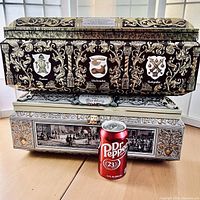 Two stacked large German cookie tin chests with a Dr Pepper can in front for size reference. The top tin has ornate gold, white, and black scrollwork with three heraldic shield images and the text 'Nürnberg' on the front.