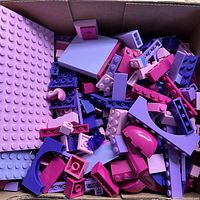 Top view showing pink and purple LEGO bricks and pieces of various shapes including plates, curved and arched elements.