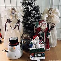 Photo showing all lot items including flocked tree, angels, Santa doorstop, and candle holders