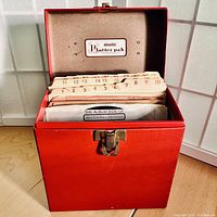 Red textured vintage Amfile Platter-Pak carrying case with numbered dividers and lid open showing interior.