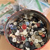 Vintage metal Christmas tin filled with varied vintage buttons loose inside.