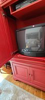 Open view showing interior of the armoire with a CRT TV and electronic device shelf.