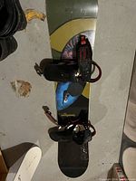 Top view of Burton snowboard showing bindings attached and part of graphic design on board top.