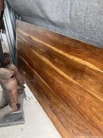 Photo showing the rich wood grain tabletop head on, leaning upright against a wall.