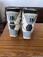 Rear view of white and grey Burton snowboard boots showing heel and back side details.