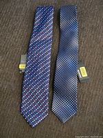 Two men's ties laid flat, showing geometric and dot patterns with tags attached