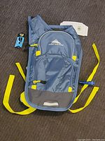 Full view of blue and gray High Sierra hydration backpack with yellow straps and zipper pulls, tags attached.