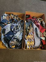 Two boxes filled with an assortment of men's neck ties showing multiple colors and patterns