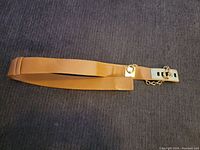 Full view of the brown leather belt laid flat