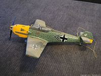 Full side view of the model airplane showing camouflage and German insignia with yellow nose.