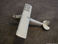 White model airplane with registration NX211 on wing, Ryan NYP on tail, and propeller visible from side angle